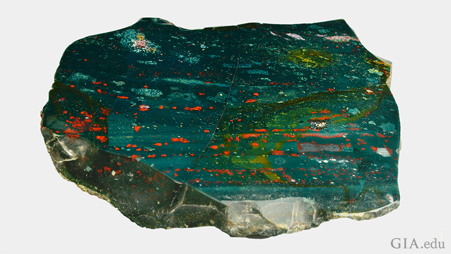 A giant slab of the March birthstone, bloodstone, is green with red, yellow, and white spots. A giant slab of the March birthstone, bloodstone, is green with red, yellow, and white spots.