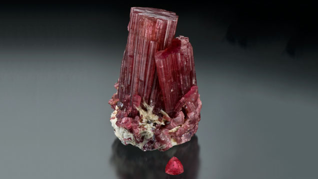 Rubellite Tourmaline Crystal. The colors displayed by the crystal and fashioned gem are typical of tourmaline with the trade name of rubellite. - Courtesy William F. Larson, Pala International