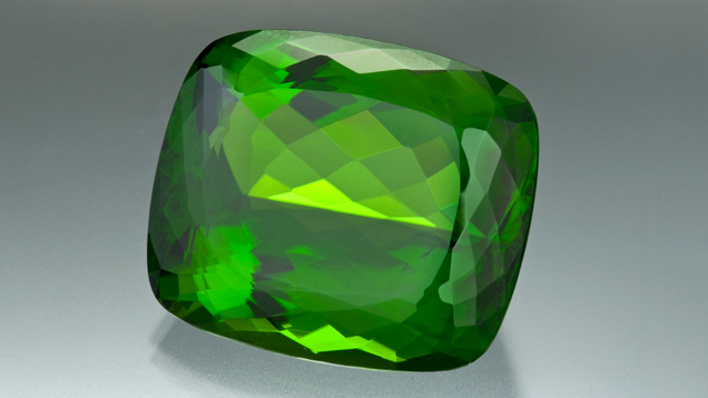130.60-ct Cushion-Shaped Peridot. This magnificent 130.60-carat antique cushion-cut peridot displays the gem's finest attributes: a medium-toned, highly saturated yellowish green hue and high clarity.