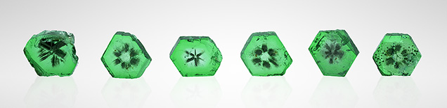 Six emerald wafers displayed a trapiche-like pattern. Six emerald wafers displayed a trapiche-like pattern.
