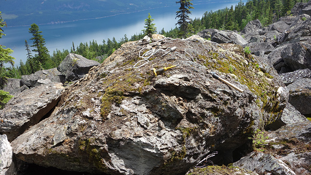 Figure 5. Cordierite-gedrite-biotite-garnet boulder at the Blue Arrow occurrence. Photo by D.J. Lake. Figure 5. Cordierite-gedrite-biotite-garnet boulder at the Blue Arrow occurrence. Photo by D.J. Lake.