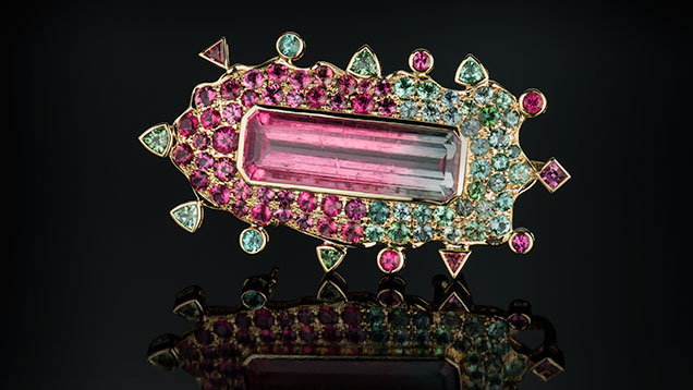 Bicolor Tourmaline Pin. Figure 2. This 31.34 ct bicolor tourmaline pin, which contains gemstones exclusively from the Stewart Lithia mine in San Diego County, has an emotional connection for the artist. Photo by Robert Weldon/ GIA; courtesy of Paula Crevoshay.