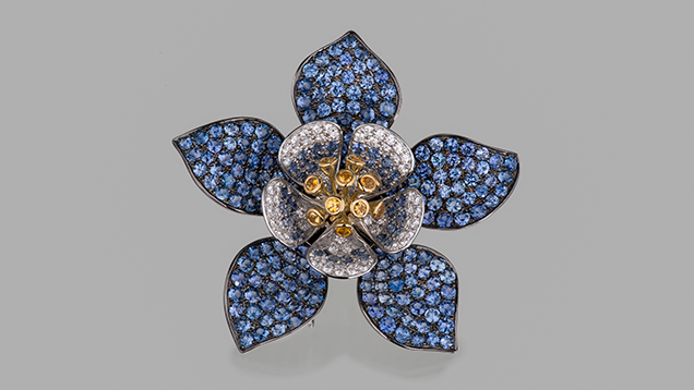 Paula Crevoshay’s “Yogo Columbine” sapphire pendant. Figure 2. Paula Crevoshay’s “Yogo Columbine” pendant displays the remarkably consistent blue color of Yogo sapphires: 243 in all, with a total weight of 13.89 carats. The piece also contains 0.59 ct of yellow sapphires and 1.37 ct of diamonds, set in 18K yellow and white gold. Photo by Orasa Weldon.