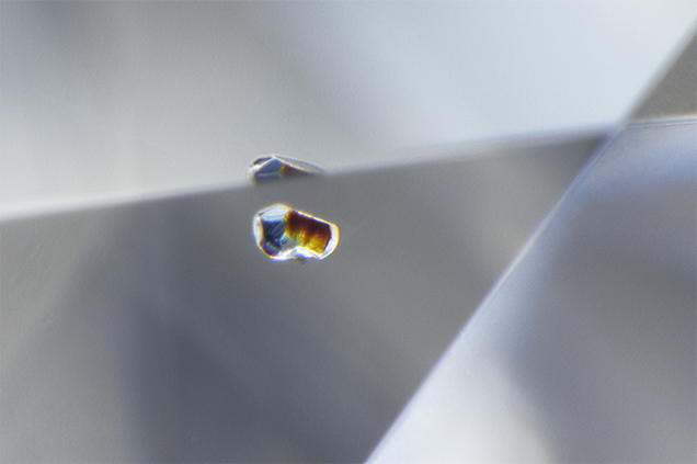 Omphacite (left) and chromite (right) crystals composing a "bimineralic inclusion" in a diamond. Omphacite (left) and chromite (right) crystals composing a "bimineralic inclusion" in a diamond.