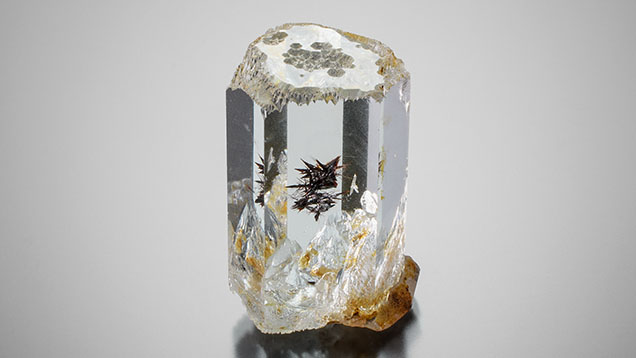 Figure 1. Measuring 26.36 mm in length and weighing 56.00 ct, this Pakistani aquamarine crystal is host to an eye-visible 7.20 mm mineral inclusion cluster. Photo by Annie Haynes. Figure 1. Measuring 26.36 mm in length and weighing 56.00 ct, this Pakistani aquamarine crystal is host to an eye-visible 7.20 mm mineral inclusion cluster. Photo by Annie Haynes.