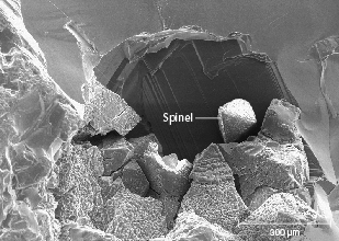 Figure 27. SEM image of the surface of a sapphire from Missouri River showing the spinel coating sometimes seen in stones from this deposit but never in sapphire from Rock Creek or Dry Cottonwood Creek. Image by Richard Berg. Figure 27. SEM image of the surface of a sapphire from Missouri River showing the spinel coating sometimes seen in stones from this deposit but never in sapphire from Rock Creek or Dry Cottonwood Creek. Image by Richard Berg.