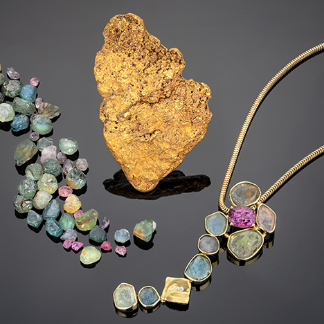 Figure 5. Early gold prospecting led to the discovery of Montana sapphire. This gold nugget from Scratchgravel Hills measures about 4 × 7 cm; courtesy of Bill Larson. The rough sapphires and the necklace containing rough sapphires and a 3.5 ct lavender spinel cut by Larry Woods are courtesy of Diana Widman. Photo by Robert Weldon. Figure 5. Early gold prospecting led to the discovery of Montana sapphire. This gold nugget from Scratchgravel Hills measures about 4 × 7 cm; courtesy of Bill Larson. The rough sapphires and the necklace containing rough sapphires and a 3.5 ct lavender spinel cut by Larry Woods are courtesy of Diana Widman. Photo by Robert Weldon.