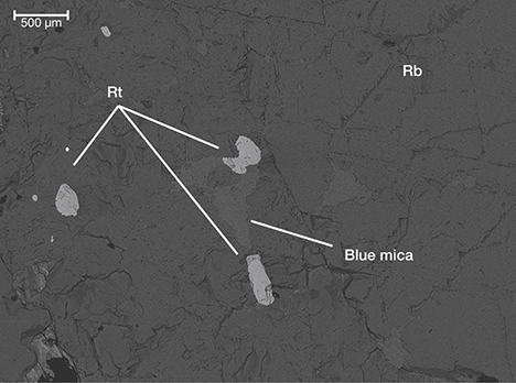 Backscattered electron image showing particles of blue mica and rutile inclusions in ruby from Snezhnoe, Tajikistan. Backscattered electron image showing particles of blue mica and rutile inclusions in ruby from Snezhnoe, Tajikistan.