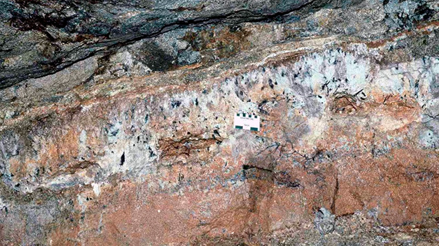 Figure 10. Underground exposure of a subhorizontal pegmatite dike at the San Diego mine near Mesa Grande in San Diego County, California, in 1986. Several open pockets, from which the contents have been removed, extend along the central portion of the dike, which is about 2 meters across from top to bottom. Courtesy of David London. Figure 10. Underground exposure of a subhorizontal pegmatite dike at the San Diego mine near Mesa Grande in San Diego County, California, in 1986. Several open pockets, from which the contents have been removed, extend along the central portion of the dike, which is about 2 meters across from top to bottom. Courtesy of David London.
