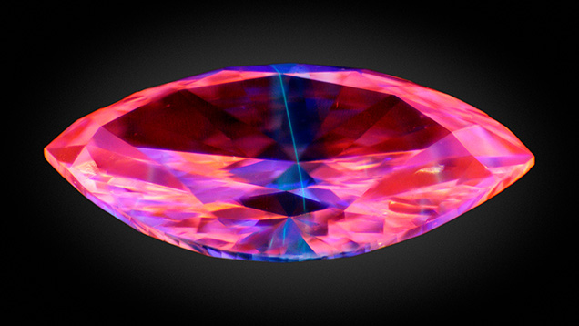 Figure 1. Deep-UV imaging of the 0.07 ct multilayered laboratory-grown diamond (4.20 × 2.26 × 1.27 mm) showing fluorescence of a thin blue-green layer between two pink-orange CVD layers. Image by Sean O’Neal. Figure 1. Deep-UV imaging of the 0.07 ct multilayered laboratory-grown diamond (4.20 × 2.26 × 1.27 mm) showing fluorescence of a thin blue-green layer between two pink-orange CVD layers. Image by Sean O’Neal.