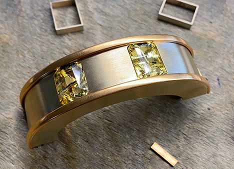 Two faceted yellow sapphires are set in a bracelet.