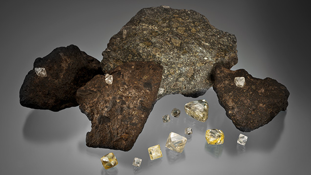 Figure 9. Diamond crystals (1.24–22.32 ct) and samples of diamond-bearing kimberlite. Photo by Orasa Weldon. The loose crystals were donated to GIA by De Beers as part of the Sir Ernest Oppenheimer Student Collection. Figure 9. Diamond crystals (1.24–22.32 ct) and samples of diamond-bearing kimberlite. Photo by Orasa Weldon. The loose crystals were donated to GIA by De Beers as part of the Sir Ernest Oppenheimer Student Collection.