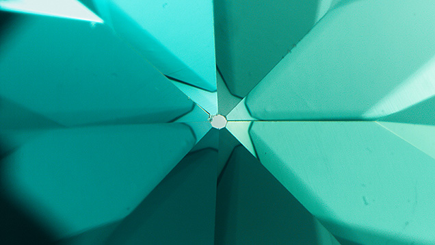Figure 5. This “umbrella effect” at the culet of a diamond was created by cyclotron treatment, a type of artificial irradiation. Photomicrograph by Nicole Ahline; field of view 2.90 mm. Figure 5. This “umbrella effect” at the culet of a diamond was created by cyclotron treatment, a type of artificial irradiation. Photomicrograph by Nicole Ahline; field of view 2.90 mm.
