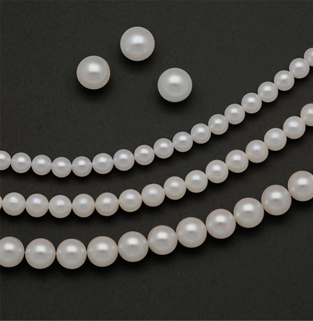 Three loose white freshwater pearls above three strands of freshwater and akoya cultured pearls of varying sizes Three loose white freshwater pearls above three strands of freshwater and akoya cultured pearls of varying sizes