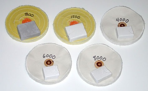 「800」と「1500」と表示された2つの加工済みイエローホイールと、「4000」、「6000」、「8000」と表示された3つの白いホイールは、バフに塗布されたプラチナ用研磨剤の研磨グレードを表している。 「800」と「1500」と表示された2つの加工済みイエローホイールと、「4000」、「6000」、「8000」と表示された3つの白いホイールは、バフに塗布されたプラチナ用研磨剤の研磨グレードを表している。