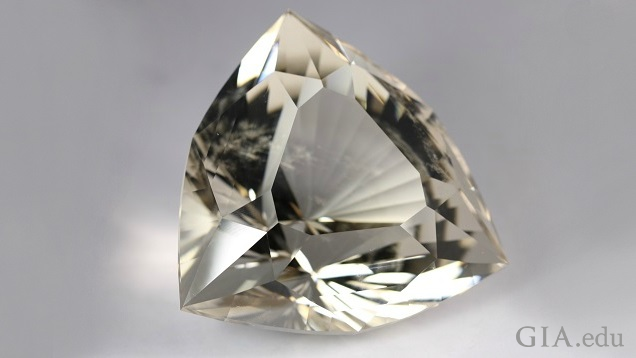 Six-sided shield-shaped, intricately carved topaz.