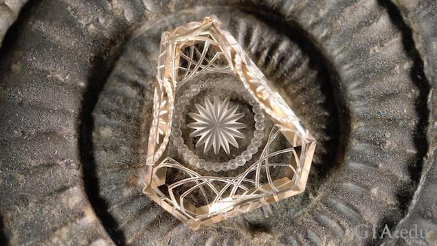 An octagonal shaped, intricately carved ametrine (citrine and amethyst).