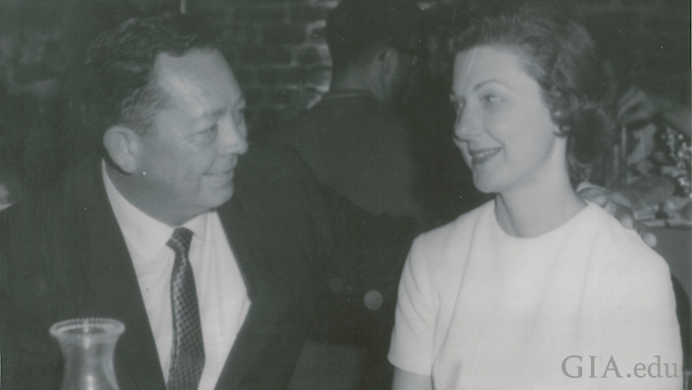 A man and woman sit at a restaurant table gazing at one another.